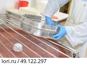Factory worker sieving ingredient into vat of food. Стоковое фото, агентство Ingram Publishing / Фотобанк Лори
