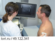 mature man getting ultrasound scan by young female doctor. Стоковое фото, агентство Ingram Publishing / Фотобанк Лори