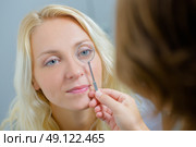 Optician checking a woman's eye. Стоковое фото, агентство Ingram Publishing / Фотобанк Лори