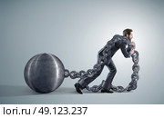 Exhausted businessman dragging heavy chains. Стоковое фото, агентство Ingram Publishing / Фотобанк Лори