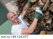 smiling man tidying up wood logs. Стоковое фото, агентство Ingram Publishing / Фотобанк Лори