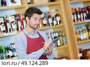 confident young sommelier writing something at his note pad. Стоковое фото, агентство Ingram Publishing / Фотобанк Лори