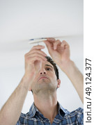 Swapping out a broken bulb. Стоковое фото, агентство Ingram Publishing / Фотобанк Лори