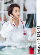 doctor woman with fluorography talking phone. Стоковое фото, агентство Ingram Publishing / Фотобанк Лори