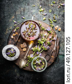 Healthy herbal tea preparation with fresh healing herbs, cup and vintage tea strainer on dark rustic wooden background, top view. Стоковое фото, агентство Ingram Publishing / Фотобанк Лори