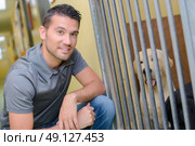 Man next to dog kennel. Стоковое фото, агентство Ingram Publishing / Фотобанк Лори