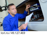 Mechanic checking electrics on campervan. Стоковое фото, агентство Ingram Publishing / Фотобанк Лори