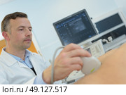 doctor doing ultrasound on pregnant woman in clinic. Стоковое фото, агентство Ingram Publishing / Фотобанк Лори