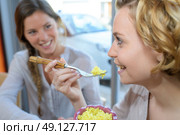 two girls having fun talking and eating in asian restaurant. Стоковое фото, агентство Ingram Publishing / Фотобанк Лори