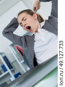 sleepy young business woman sitting at office desk. Стоковое фото, агентство Ingram Publishing / Фотобанк Лори