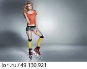 Cheerful young roller skater with a curly hairstyle. Стоковое фото, агентство Ingram Publishing / Фотобанк Лори
