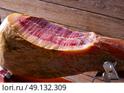 Iberian ham pata negra from Spain cut by hand on wood. Стоковое фото, агентство Ingram Publishing / Фотобанк Лори