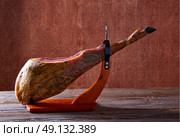 Iberian ham pata negra from Spain on wood background. Стоковое фото, агентство Ingram Publishing / Фотобанк Лори