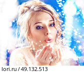 Blond woman blowing a magic dust. Стоковое фото, агентство Ingram Publishing / Фотобанк Лори