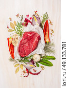 Raw meat, composing with herbs,spices and seasoning on white wooden background, ingredients for cooking, top view. Стоковое фото, агентство Ingram Publishing / Фотобанк Лори