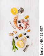 Seafood composing with olives and lemon on white wooden table, top view. Стоковое фото, агентство Ingram Publishing / Фотобанк Лори