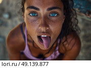 A person dressed as a fantasy character with an elaborate headpiece and armor playfully sticking out their tongue during daylight. Стоковое AI-изображение, AI-художник Данила Большаков / Фотобанк Лори