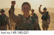 A woman in a military uniform stands tall, her right arm is raised in a fist pump after a successful mission. The background filled with tired but Happy colleagues in the military. Стоковое AI-видео, аниматор Sergey Grishin / Фотобанк Лори