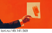 An individual holding a piece of paper with a handprint on it. Стоковое AI-изображение, AI-художник Данила Большаков / Фотобанк Лори