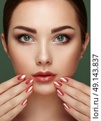 Beauty brunette woman with perfect makeup. Glamour girl. Red lips and nails. Perfect eyebrows. Skin care foundation. Beauty girls face isolated on green background. Fashion photo. Стоковое фото, агентство Ingram Publishing / Фотобанк Лори