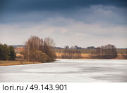 Early spring. Mud season. Lake under ice and snow melting. Cloudy spring day. Spring rural scene. Стоковое фото, агентство Ingram Publishing / Фотобанк Лори