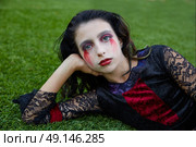 Halloween kid girl custome with bloody makeup on backyard turf. Стоковое фото, агентство Ingram Publishing / Фотобанк Лори