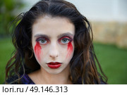 Halloween kid girl custome with bloody makeup on backyard turf. Стоковое фото, агентство Ingram Publishing / Фотобанк Лори