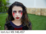 Halloween kid girl custome with bloody makeup on backyard turf. Стоковое фото, агентство Ingram Publishing / Фотобанк Лори