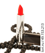 Red lipstick and black bead over white background. Стоковое фото, агентство Ingram Publishing / Фотобанк Лори