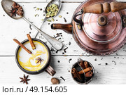 Masala tea hot Indian with milk. Masala tea in clay mug with spices on light background. Стоковое фото, агентство Ingram Publishing / Фотобанк Лори