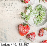 Fresh sliced Strawberries with powdered sugar and mint leaves in bowl on light rustic background, top view. Стоковое фото, агентство Ingram Publishing / Фотобанк Лори