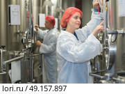 a worker checking a vat for making wine. Стоковое фото, агентство Ingram Publishing / Фотобанк Лори