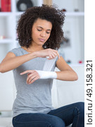 woman bandaging her wrist indoors. Стоковое фото, агентство Ingram Publishing / Фотобанк Лори