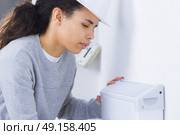 Female worker fitting appliance to wall. Стоковое фото, агентство Ingram Publishing / Фотобанк Лори