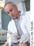 podiatrist working on a patient in a clinic. Стоковое фото, агентство Ingram Publishing / Фотобанк Лори