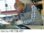 mechanic using repairing equipment to fix damaged windshield. Стоковое фото, агентство Ingram Publishing / Фотобанк Лори