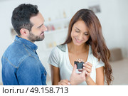 Man giving ring box to female partner. Стоковое фото, агентство Ingram Publishing / Фотобанк Лори