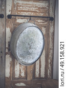 Old stylish iron tub hanging on a wooden wall with grunge paint peeling of the old planks. Стоковое фото, агентство Ingram Publishing / Фотобанк Лори