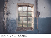 Dirty old window on a grunge wall with cracks and pealing blue paint with an electrical switch beside. Стоковое фото, агентство Ingram Publishing / Фотобанк Лори