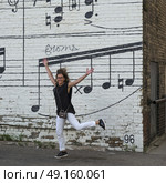 Cheerful woman in front of Schmitt Music Mural, Minneapolis, Hennepin County, Minnesota, USA. Стоковое фото, агентство Ingram Publishing / Фотобанк Лори
