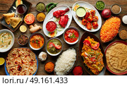 Assorted Indian recipes food various with spices and rice on wooden table. Стоковое фото, агентство Ingram Publishing / Фотобанк Лори