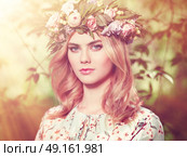 Beautiful blonde woman with flower wreath on her head. Beauty girl with flowers hairstyle. Girl in a summer forest. Fashion photo. Стоковое фото, агентство Ingram Publishing / Фотобанк Лори