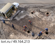 Top view of workers repairing underground heating mains through open hatches, the inscription on the truck: 'Emergency heating service' Стоковое фото, фотограф Сергей Фролов / Фотобанк Лори