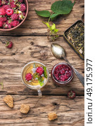berry tea with raspberries. Autumn warming and tea with raspberries on vintage wooden background. Стоковое фото, агентство Ingram Publishing / Фотобанк Лори