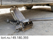 Подкатной домкрат поднимает машину, шиномонтаж в автосервисе. Стоковое фото, фотограф Екатерина Якименко / Фотобанк Лори