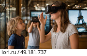 Child using virtual reality headset for metaverse, child looking into VR glasses. Little girl boy with futuristic glasses having fun, teenager playing video games. Technology, simulator, oculus future. Стоковое AI-изображение, AI-художник ALLA YURTAYEVA / Фотобанк Лори