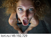 A woman contorting her face into a humorous expression, mouth wide open in a funny gesture. Стоковое AI-изображение, AI-художник Данила Большаков / Фотобанк Лори