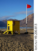 red flag water lifeguard chair cabin in spain  lanzarote  rock stone sky cloud beach  musk pond  coastline and summer . Стоковое фото, агентство Ingram Publishing / Фотобанк Лори