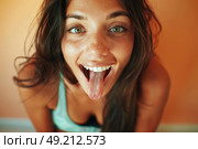 Charming woman humorously sticks out her tongue, creating a funny expression. Стоковое AI-изображение, AI-художник Данила Большаков / Фотобанк Лори