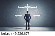 Man in suit facing balance scale symbolizing justice, decision making, law, business ethics, fairness and accountability in leadership. Стоковое AI-изображение, AI-художник Ольга Сухарева / Фотобанк Лори